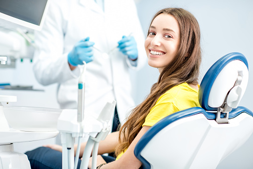 Happy woman smiling in dental chair with dentist at Highridge Dental Care in Folsom, CA